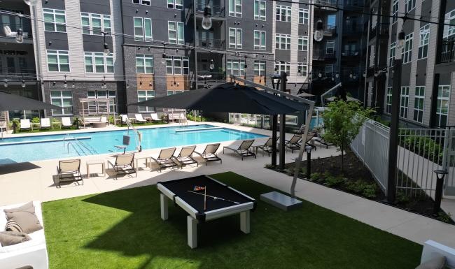 a pool and chairs by a building
